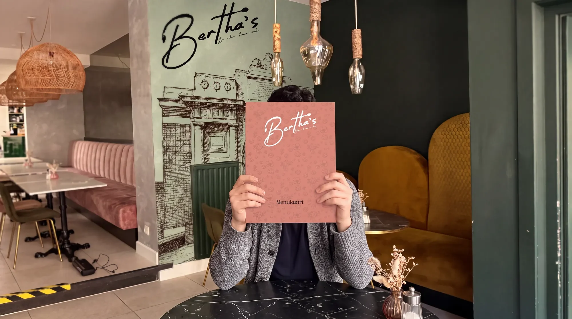 Interieur van Bertha's met het logo op de muur